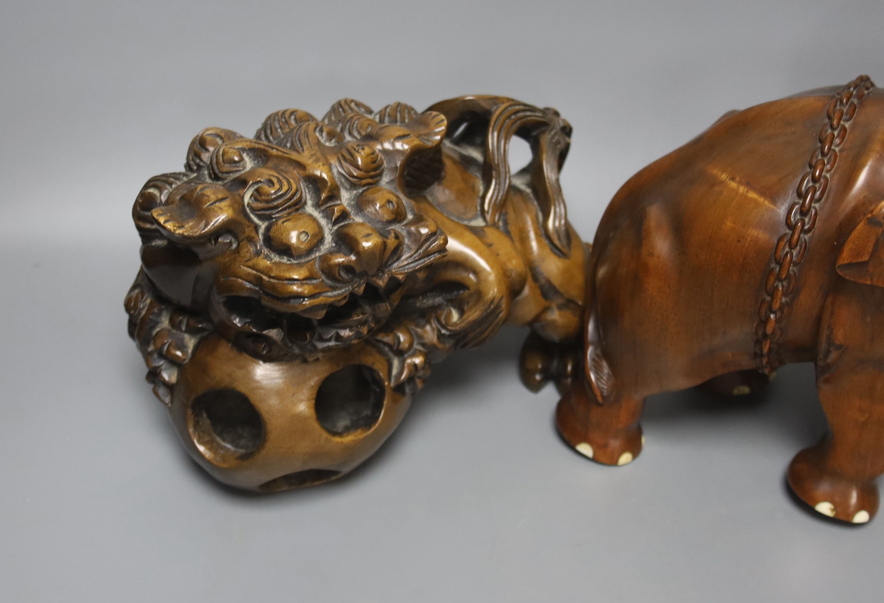 An Indian padouk wood figure of an elephant and a pair of wood figures of Buddhist lions 17cm